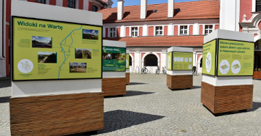 Na zdjęciu zielone plansze wystawy, w tle budynek urzędu, przed nim rowery